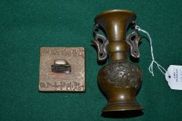 A Chinese square bronze seal and a small Chinese bronze vase.