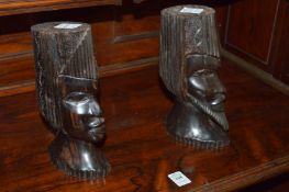 A pair of carved wood busts of a man and woman.