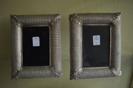 A pair of white metal photograph frames.