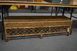 A wicker work long stool.