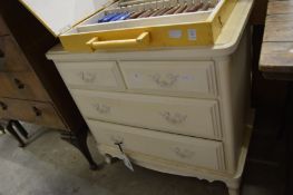 A cream painted chest of drawers.
