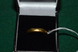 A 22cct gold wedding band.