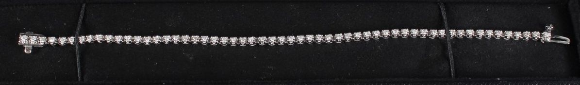 A 9CT WHITE GOLD AND DIAMOND LINE BRACELET.
