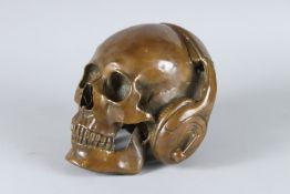 A HEAVY BRONZE SKULL with headphones. 15cms.