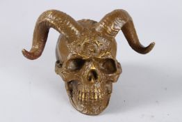 A BRONZE SKULL with horns. 4ins high.