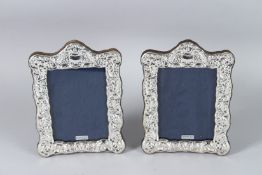 A PAIR OF EMBOSSED SILVER PHOTOGRAPH FRAMES. 16cms x 13cms.