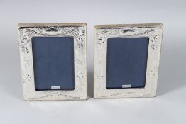 A PAIR OF ART NOUVEAU DESIGN SILVER PHOTOGRAPH FRAMES. 18cms x 12cms.