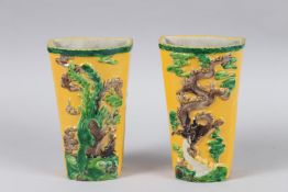A PAIR OF CHINESE YELLOW PORCELAIN WALL POCKET VASES decorated with dragons. 16cm long