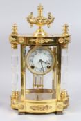 A GOOD GILT SERPENTINE SHAPED REGULATOR CLOCK with crystal columns and urn finial. 16ins high.