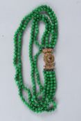 A VERY GOOD FOUR ROW JADE NECKLACE with 18ct gold clasp.