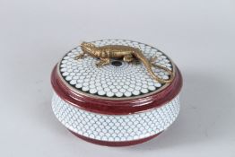 A PORCELAIN CIRCULAR BOX AND COVER with a metal lizard. 12cms.