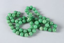 A STRING OF JADE BEADS. 70cms long.
