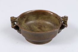 A CHINESE BRONZE CIRCULAR DRAGON BOWL. 3.5ins diameter.