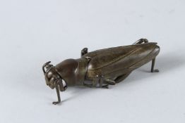 A BRONZE RETICULATED LOCUST. 7cms.