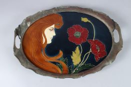 AN ART NOUVEAU CERAMIC TILE, set with a metal mount as a tray, a profile of a woman with long