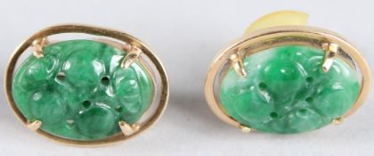 A PAIR OF GOLD AND CARVED JADE OVAL EARRINGS.