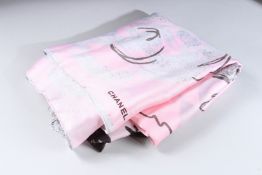 A CHANEL PINK SILK SCARF in a Chanel box.