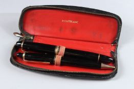 TWO MONTBLANC PENS in a leather case.