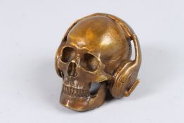 A BRONZE SKULL with headphones. 3ins high.