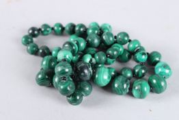 A STRING OF MALACHITE BEADS. 24ins long.