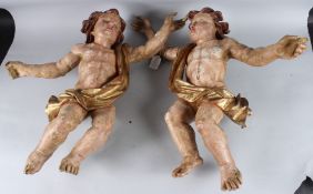 A PAIR OF 18TH CENTURY CARVED WOOD, PAINTED AND GILDED CHERUBS. 50cms long.