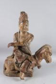 A CHINESE CARVED WOOD FIGURE OF GUAN PING, also known as KWAN-YIN, sitting on a mythological