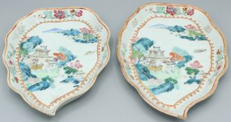 A SUPERB PAIR OF CHINESE KANG HSI PORCELAIN LEAF SHAPED DISHES. With buildings, bridges, trees and