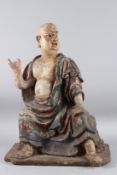 A CHINESE CARVED WOOD LUOHAN BUDDHIST FIGURE OF RAKAN (ARHAT) wearing a robe. 60cms high.