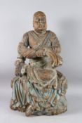 A CARVED WOOD STATUE OF A BUDAI, also known as The Laughing Buddha, sitting cross legged, wearing