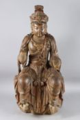 AN EARLY CARVED WOOD AND PAINTED FIGURE OF GUANYIN, shown in a relaxed and welcoming posture.