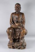 A LARGE CARVED WOOD FIGURE OF LUOHAN, also known as 