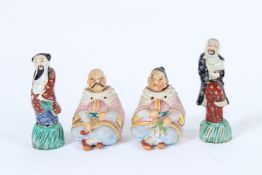 A SMALL PAIR OF BISQUE NODDERS, 8cms high, and a pair of porcelain figures, 10cms high (4).
