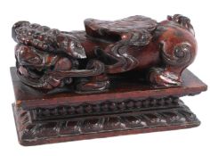 A LARGE CARVED WOODEN FOO DOG on a base. 30cms high.