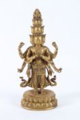 A GOOD GILT BRONZE MULTI-HEAD AND ARMS DEITY, on an oval base. 28cms high.