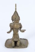 A SMALL ISLAMIC BRONZE FIGURE holding a bowl. 17cms high.