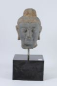 A CARVED STONE HEAD OF BUDDHA from the GANDHARA REGION. 20cms high, on a marble base.