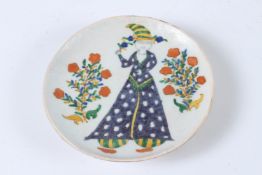 A TURKISH KUTAHYA PLATE with a woman and orange flowers. 14cms diameter.