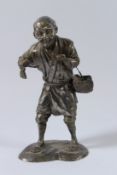 A JAPANESE METAL FIGURE OF A MAN, possibly a farmer, carrying a basket. Impressed mark on the