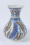 A TURKISH OTTOMAN IZNIK VASE with green and blue leaves. 28cms high.