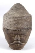 A SOUTH EAST ASIA CARVED STONE HEAD the hat lifts off to reveal a storage jar. 26cms high.