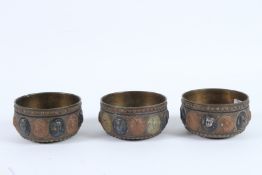 THREE 19TH CENTURY INDIAN TANJORE SILVER AND COPPER INLAID BRASS BOWLS with figural decoration.