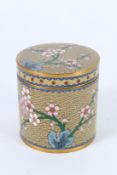 A CLOISONNE ENAMEL CIRCULAR POT AND COVER with blossom. 8cms high.