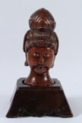 A CHINESE CARVED WOOD BUST OF A BUDDHA on a wooden base. 36cms high.