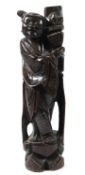 A CHINESE CARVED WOOD FIGURE WITH SILVER INLAY holding a vase. 33cms high.