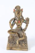 A SMALL GILT BRONZE GOD FIGURE set with coral. 14cms high.