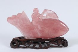 A CHINESE CARVED CRYSTAL FIGURE OF A SMALL BOY RIDING A CARP. 22cms high, on a wooden base.