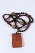 A CHINESE HORN BEAD NECKLACE AND PENDANT.