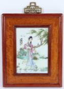 A FRAMED PORCELAIN PLAQUE of a young lady. Signed.