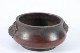 A CHINESE BRONZE CIRCULAR CENSER with lion handles. 12cms diameter.