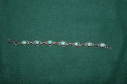 A silver and turquoise bracelet.